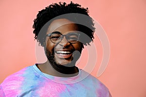 young happy african american man posing in the studio over pink background