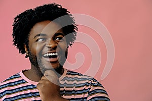 young happy african american man posing in the studio over pink background