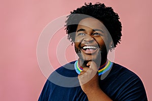 young happy african american man posing in the studio over pink background