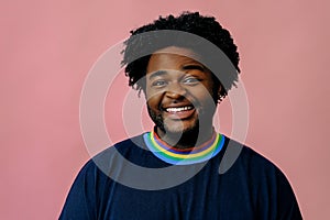 young happy african american man posing in the studio over pink background