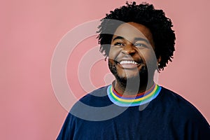 young happy african american man posing in the studio over pink background male model