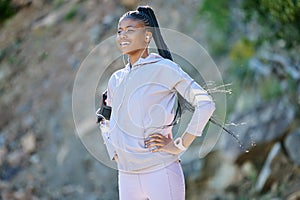 Young happy african american woman hiking on a mountain, taking a break to rest. Black ethnic fit smiling young woman