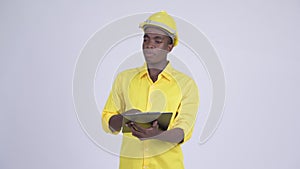 Young happy African businessman as engineer explaining while reading on clipboard