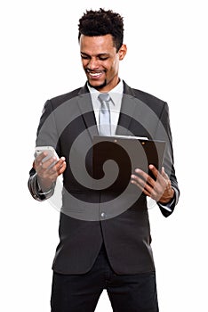 Young happy African businessman smiling while holding clipboard