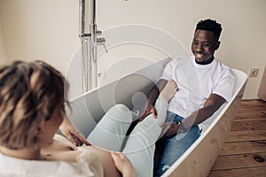 Young happy african man and caucasian pregnant woman take a bath