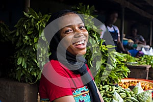 young happy african woman selling in a local market laughing