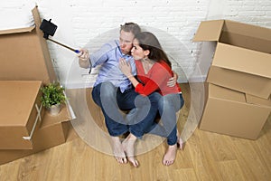 Young happy American couple sitting on floor celebrating moving in new house apartment or flat