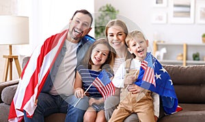 Young happy american family parents and two little kids Independence day of United States at home