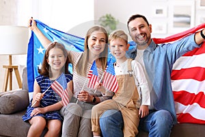 Young happy american family parents and two little kids Independence day of United States at home