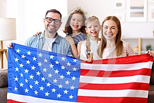 Young happy american family parents and two little kids Independence day of United States at home