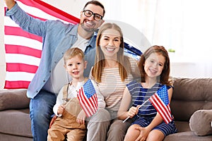 Young happy american family parents and two little kids Independence day of United States at home