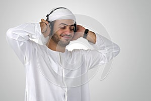 Young happy Arabian man with headphones listening to music