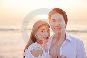 Young happy Asian couple hug on the beach, romantic travel honeymoon vacation summer holidays. Asian woman and man holding hands