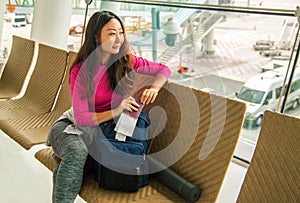 Young happy asian girl waiting for departure in international airport.