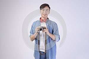 Young happy asian tourist man over white background studio, travel and holidays concept