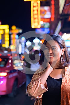 Young happy Asian tourist woman smiling at Chinatown in Bangkok