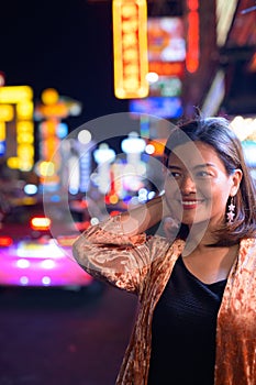 Young happy Asian tourist woman waiting at Chinatown in Bangkok