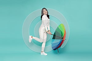 Young happy Asian woman holding colorful umbrella.