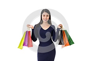 Young happy Asian woman holding shopping bags with smiley face isolated on white