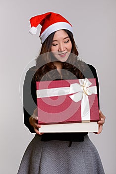 Young happy Asian woman opening gift box ready for Christmas