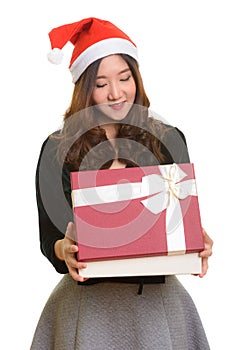 Young happy Asian woman opening gift box ready for Christmas