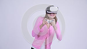 Young happy Asian woman playing games and using virtual reality headset