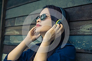 Young happy asian woman using headphone to listen to her music