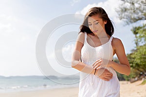 Young happy attractive and beautiful Caucasian adult woman in white summer dress enjoying summer time on tropical beach - waist up