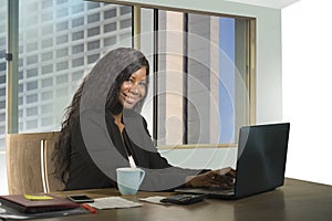 Young happy and attractive black African American businesswoman working confident at computer desk smiling satisfied in financial