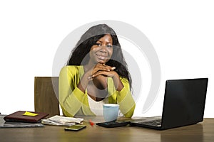 Young happy and attractive black Afro American business woman smiling cheerful and confident working at office computer desk relax