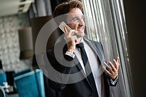 Young happy attractive business man using smartphone