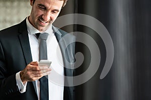 Young happy attractive business man using smartphone