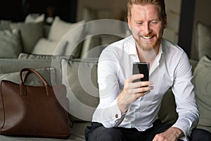 Young happy attractive business man using smartphone