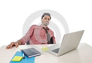 Young happy and attractive businessman in shirt and tie sitting at office desk working with computer laptop