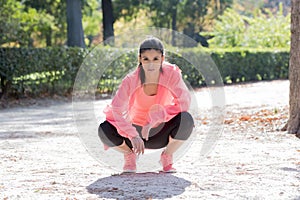 Young happy and attractive sport runner woman posing relaxed at city park looking fit and healthy after training workout on a sunn