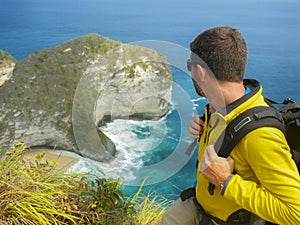 Young happy and attractive sporty hiker man with trekking backpack hiking at sea cliff landscape feeling free enjoying travel