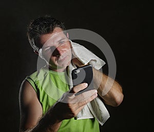 Young happy and attractive sweaty man smiling after fitness club training workout feeling satisfied checking performance data on