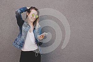Young happy attractive woman using smart phone. Gray background, copy space