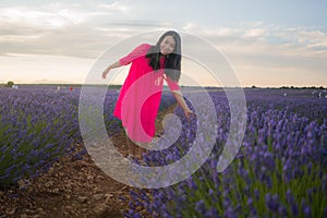 Young happy and beautiful Asian Chinese woman in Summer dress enjoying nature free and playful outdoors at purple lavender flowers
