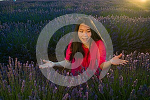 Young happy and beautiful Asian Japanese woman in Summer dress enjoying free and playful at purple lavender flowers field on