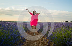 Young happy and beautiful Asian Japanese woman in Summer dress enjoying nature free and playful outdoors at purple lavender