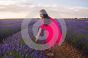 Young happy and beautiful Asian Japanese woman in Summer dress enjoying nature free and playful outdoors at purple lavender