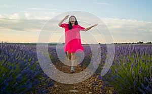 Young happy and beautiful Asian Japanese woman in Summer dress enjoying nature free and playful outdoors at purple lavender