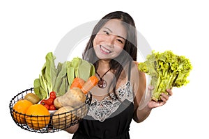 Young happy and beautiful Asian Korean woman holding basket full of vegetables smiling cheerful holding green lettuce in healthy