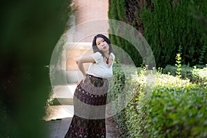 Young happy and beautiful Asian Korean woman posing outdoors happy and cheerful at city park pregnant showing her belly proud