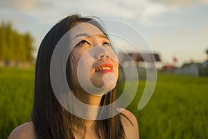 Young happy and beautiful Asian woman enjoying nature at rice field. sweet Chinese girl exploring countryside during holiday