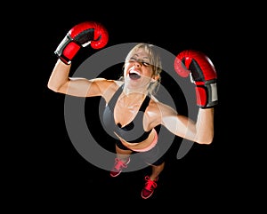 Young happy beautiful boxer girl with boxing gloves arms in victory sign with fit and healthy body