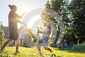 Young happy beautiful couple hosing in the garden, summer happiness and love concept