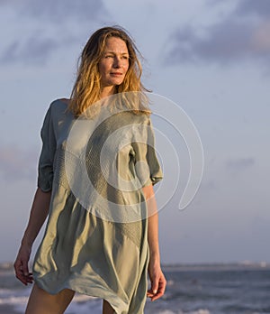 Oung happy beautiful and glamorous blond woman posing as at the beach wearing stylish dress smiling cheerful feeling fresh and fre