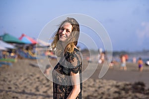 Young happy beautiful and glamorous blond woman posing as at the beach wearing stylish dress smiling cheerful feeling fresh and fr